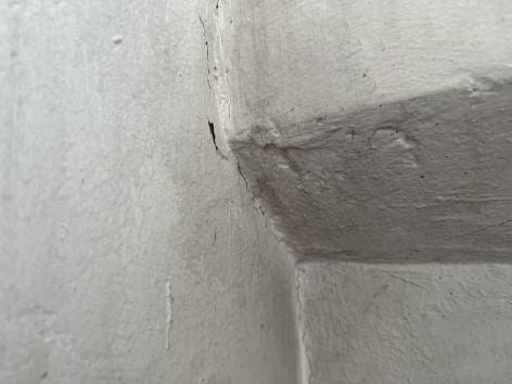 벽체 코너의 가는 실금. 함수율이 낮아 마감 균열로 판단했습니다. (균열 폭 0.3mm 판정 기준 참고)