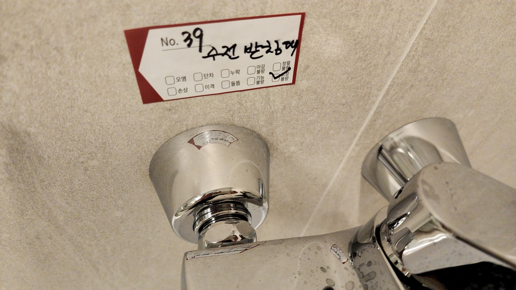 욕실 2 수전 받침대 고정불량을 표시한 실제 현장 사진.