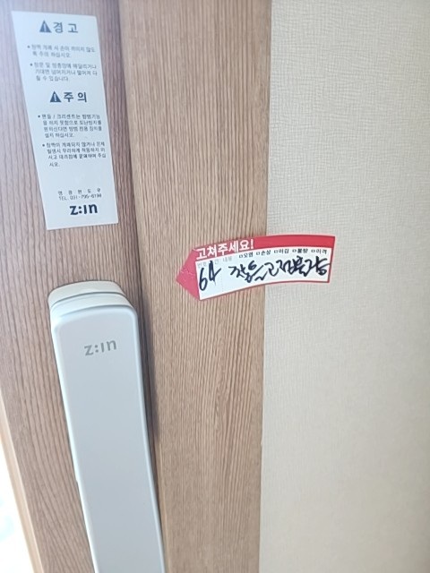 거실 창호에서 창틀 고정불량으로 기록된 위치입니다. 사진의 점검 표시는 해당 부위를 찾기 위한 현장 기록입니다.