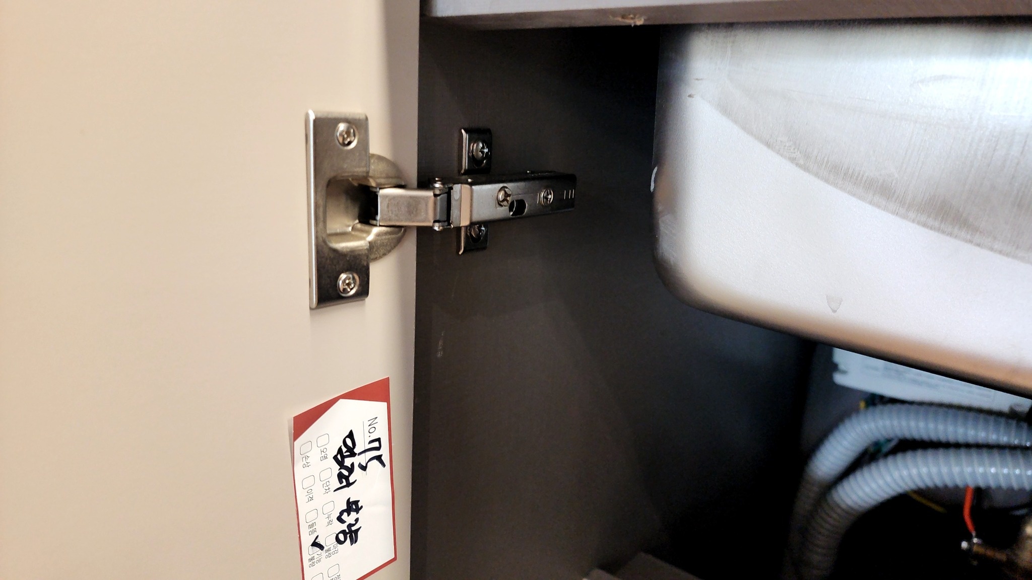 주방 싱크대 하부장 댐퍼불량 관련 실제 현장 사진. 경첩과 하부장 내부를 확인합니다.